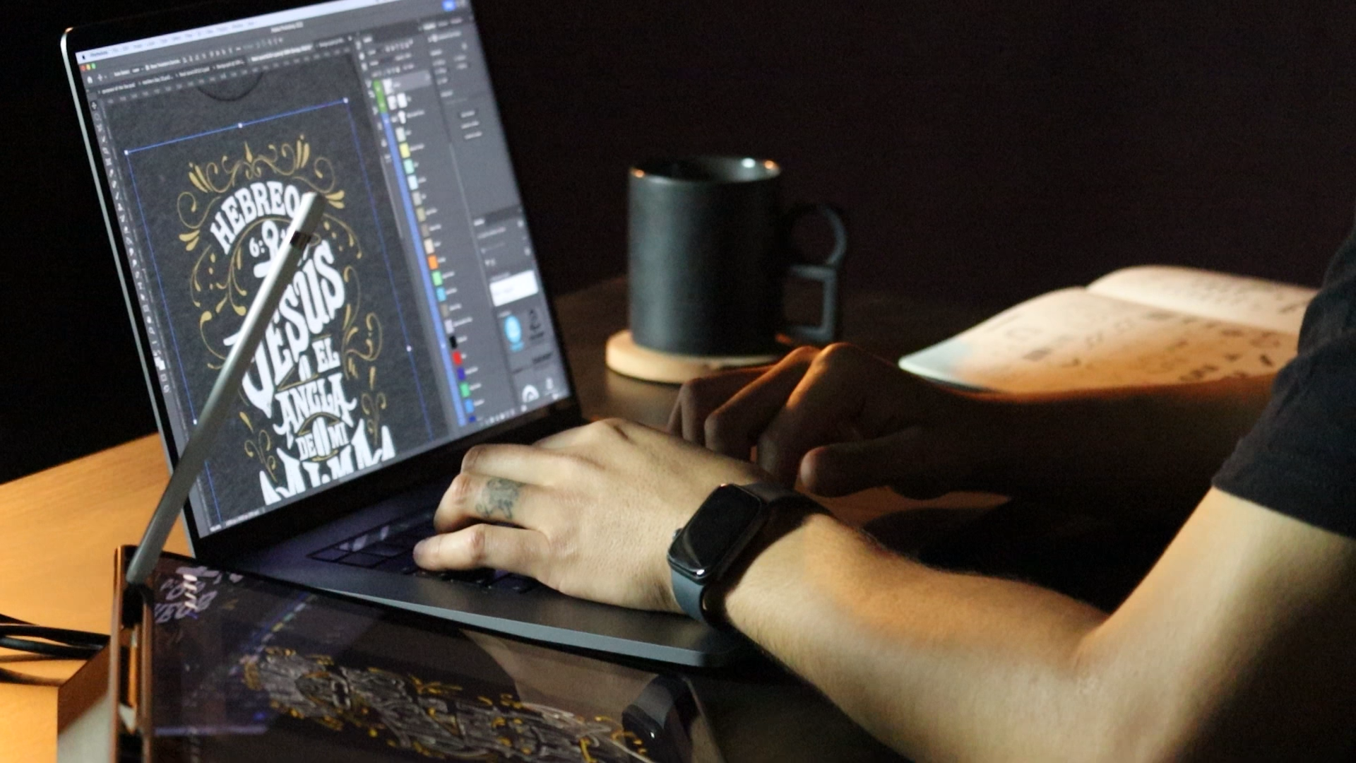 diseñador gráfico trabajando en su computadora en un diseño de camiseta con un cuaderno de bocetaje y un boceto en tableta digital a los lados